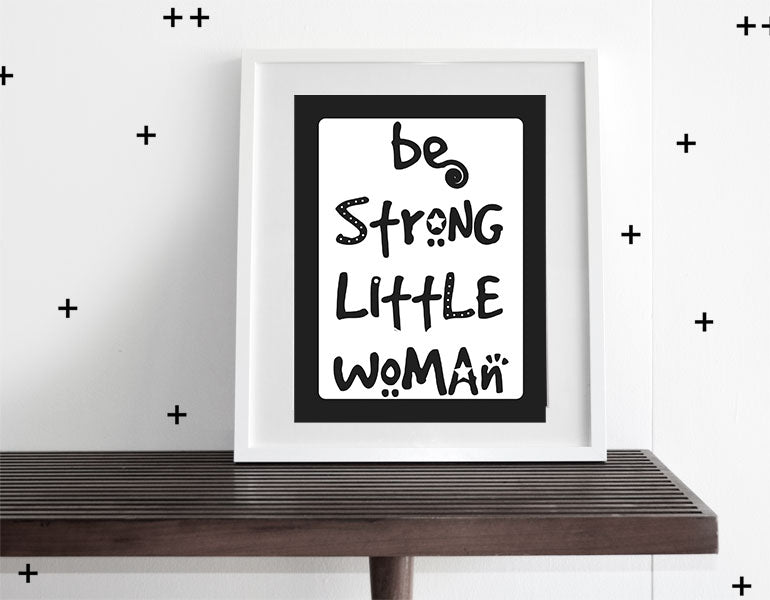 Be Strong, Little Woman Wall Art featuring modern design with motivational text, framed in a white matte, perfect for nurseries.