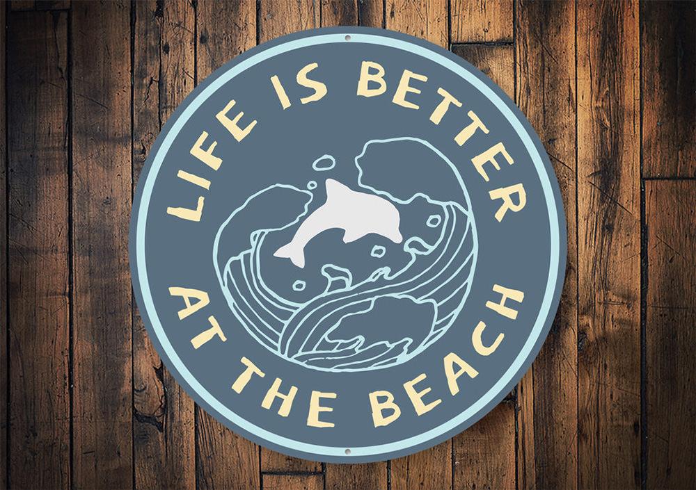 A decorative Beach Life Circle Sign made of aluminum, featuring vibrant colors and beach-themed graphics, perfect for coastal decor.