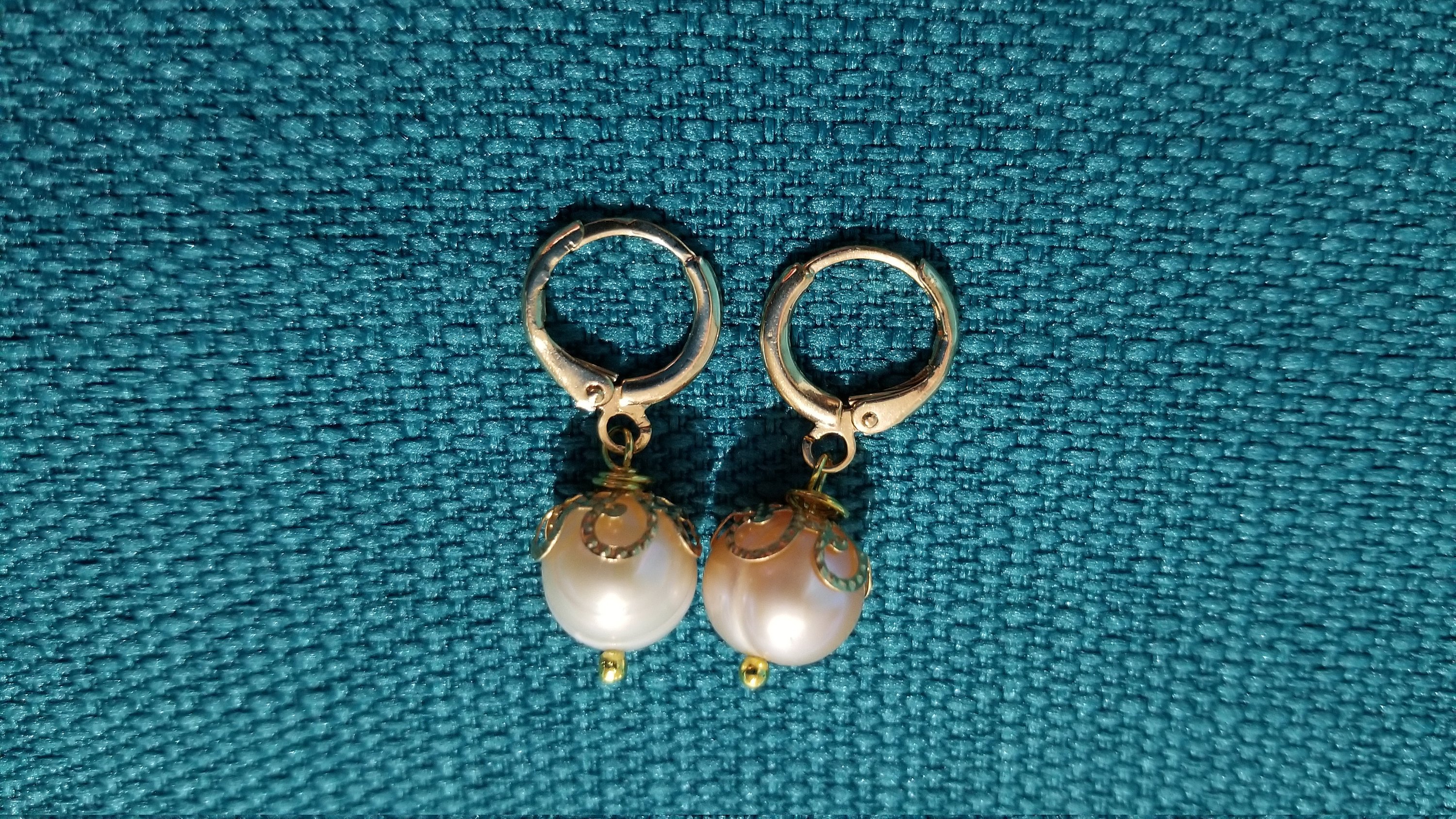 Elegant beige pearl hoop earrings with golden and silver options, showcasing a simple yet stylish design.