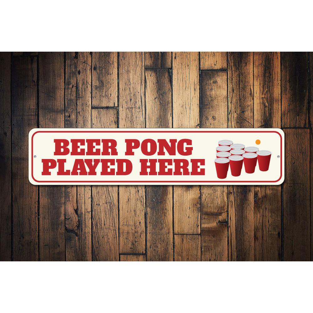 A decorative Beer Pong Played Here sign made of high-quality aluminum, featuring vibrant colors and a fun design, perfect for game rooms.