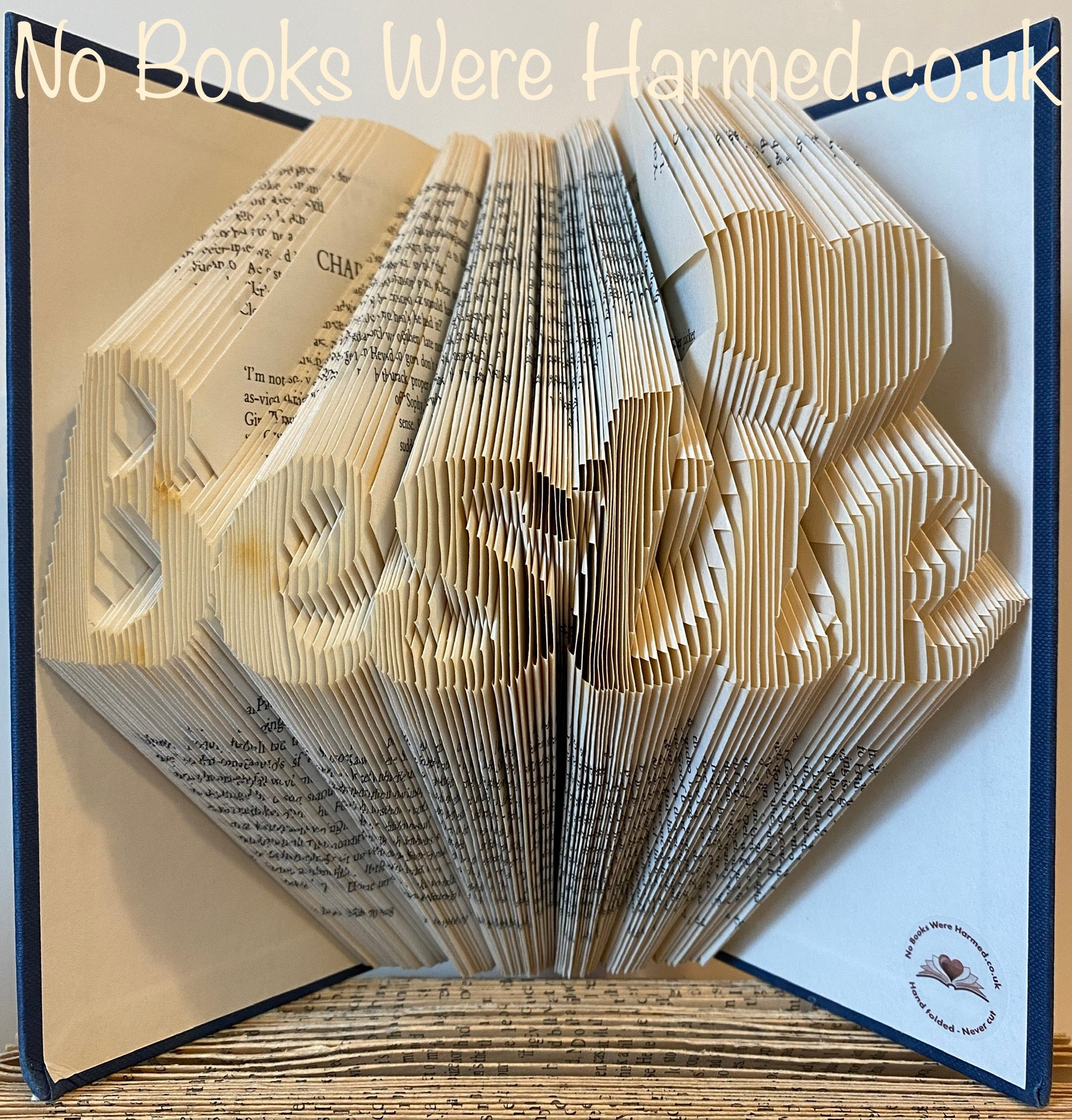 Hand-folded book art titled 'Bestie' featuring a love heart design, crafted from vintage books.