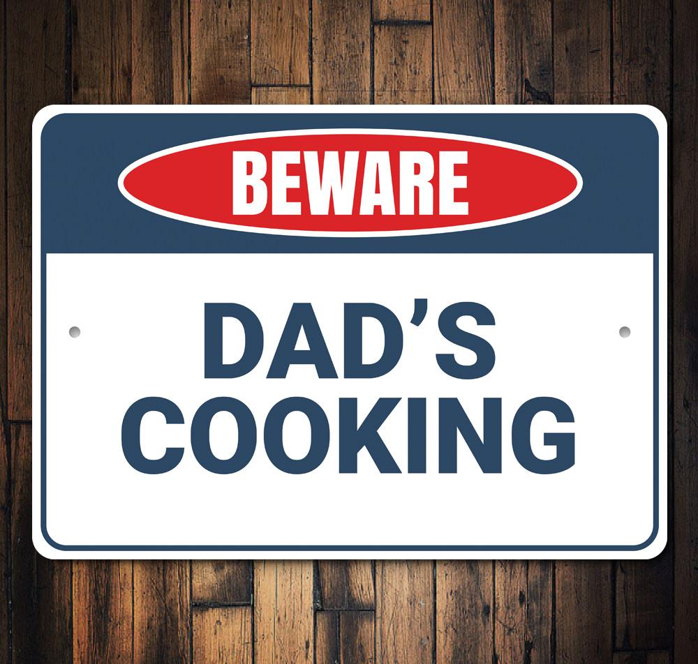 Beware Dad's Cooking Sign made of high-quality aluminum, featuring a humorous design perfect for kitchen decor.