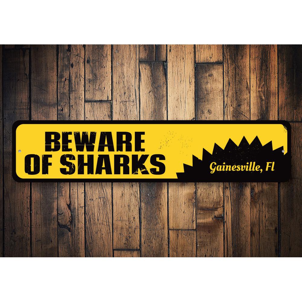 A decorative 'Beware of Sharks' sign made of aluminum, featuring vibrant colors and a playful design, perfect for beach houses and seafood restaurants.