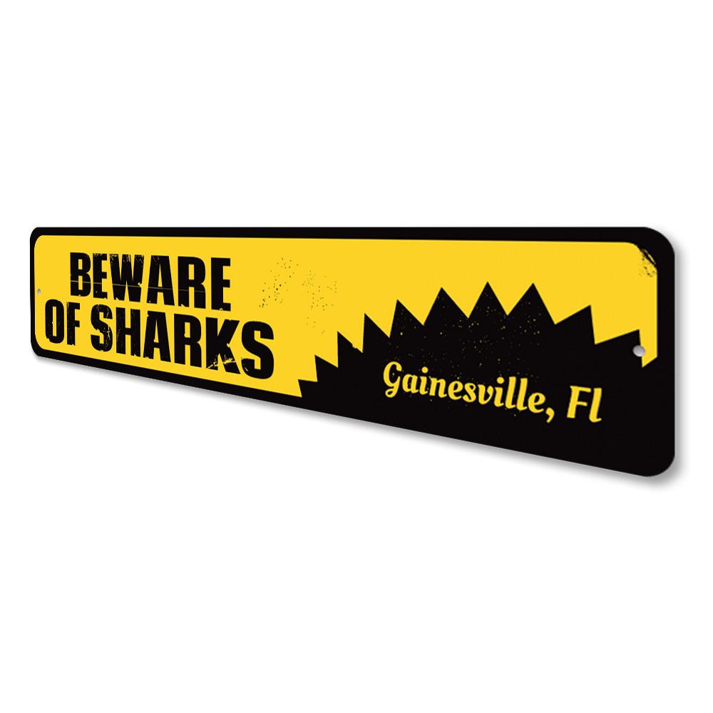 A decorative 'Beware of Sharks' sign made of aluminum, featuring vibrant colors and a playful design, perfect for beach houses and seafood restaurants.