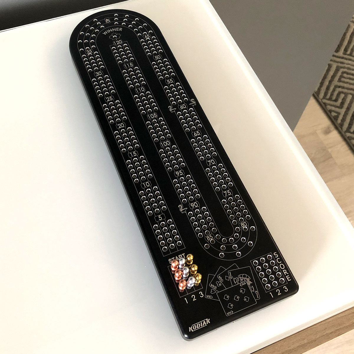 A premium Billet Aluminum Cribbage Board with anodized finishes in various colors, featuring large numbers and custom pegs.