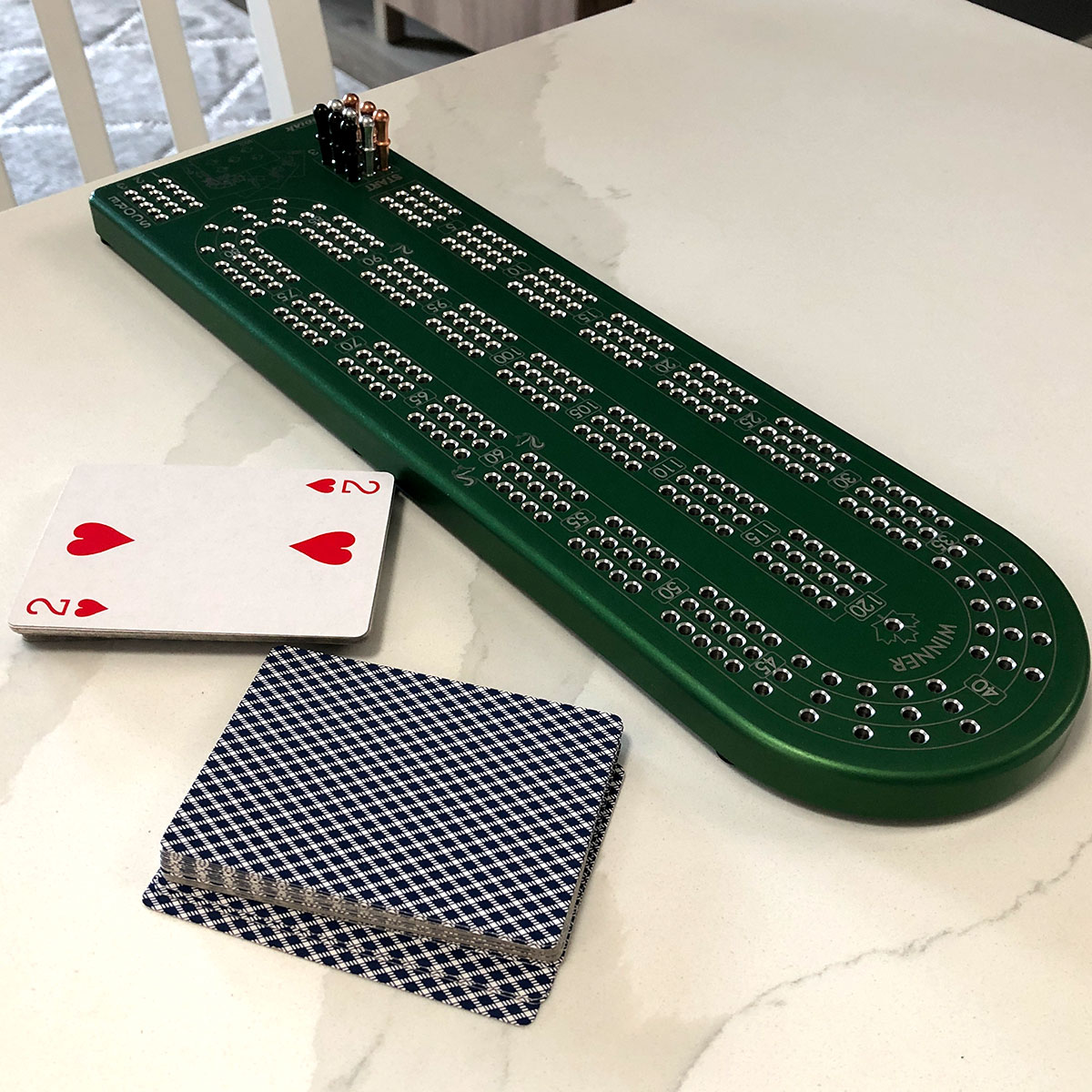 A premium Billet Aluminum Cribbage Board with anodized finishes in various colors, featuring large numbers and custom pegs.