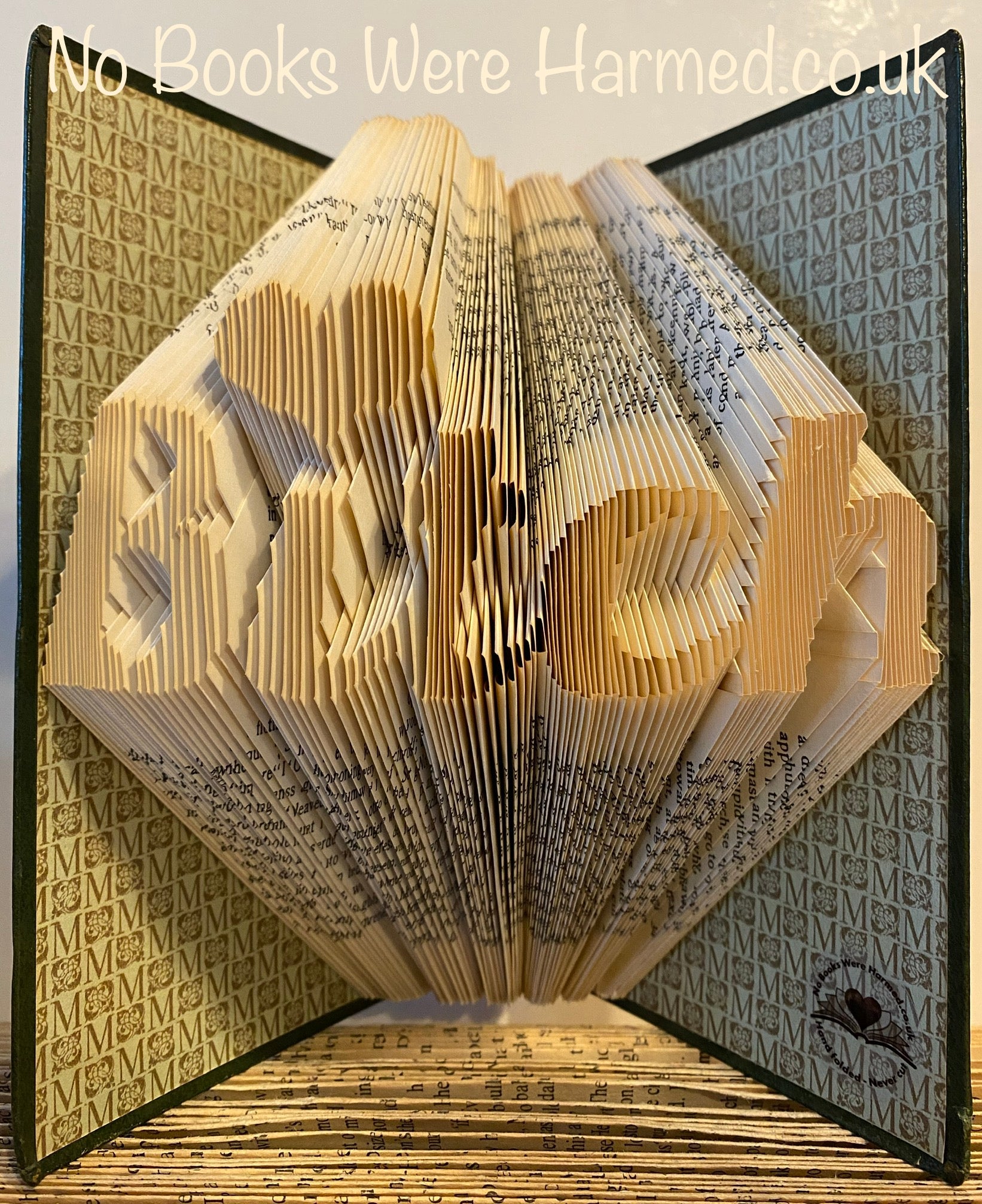 Hand-folded book art titled 'Bitch', crafted from vintage books, showcasing intricate designs and unique character.