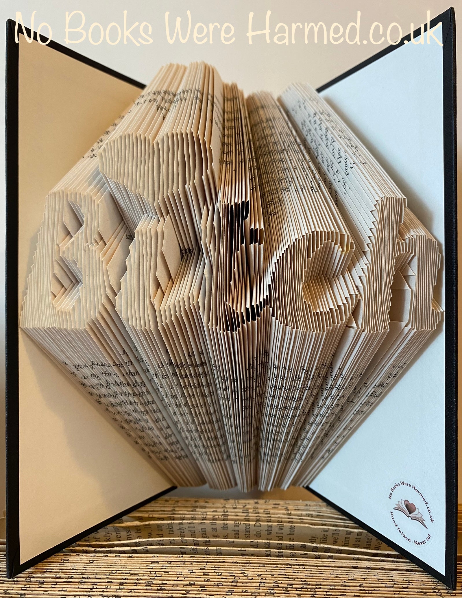 Hand-folded book art titled 'Bitch', crafted from vintage books, showcasing intricate designs and unique character.