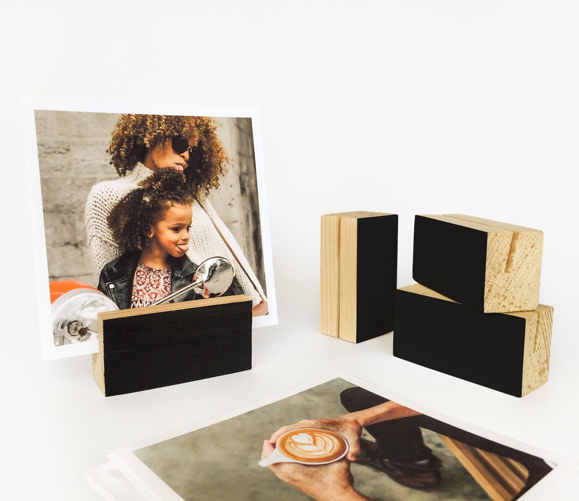 A stylish black wood block card holder displaying various art prints and photos, perfect for desks and shelves.