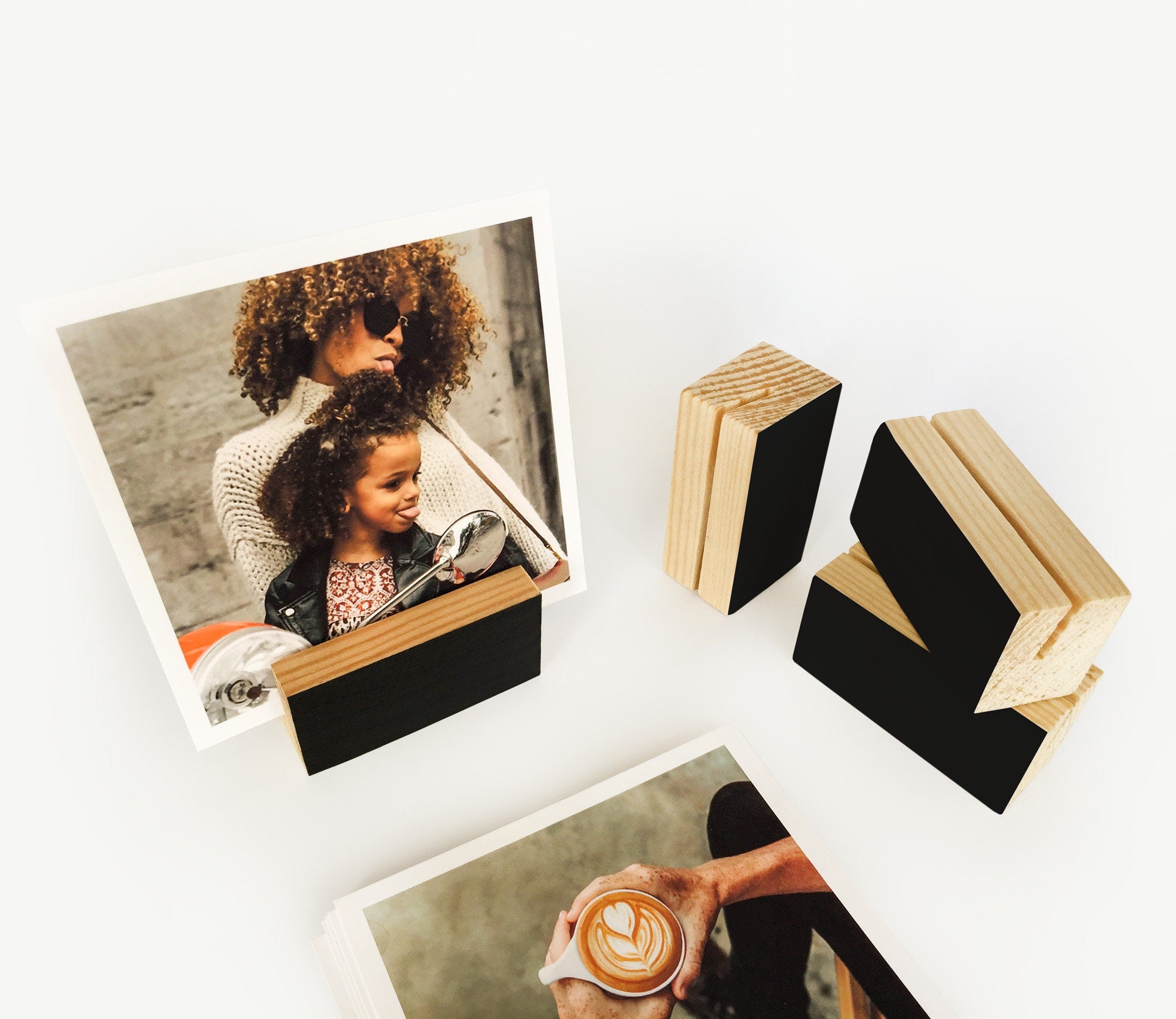 A stylish black wood block card holder displaying various art prints and photos, perfect for desks and shelves.