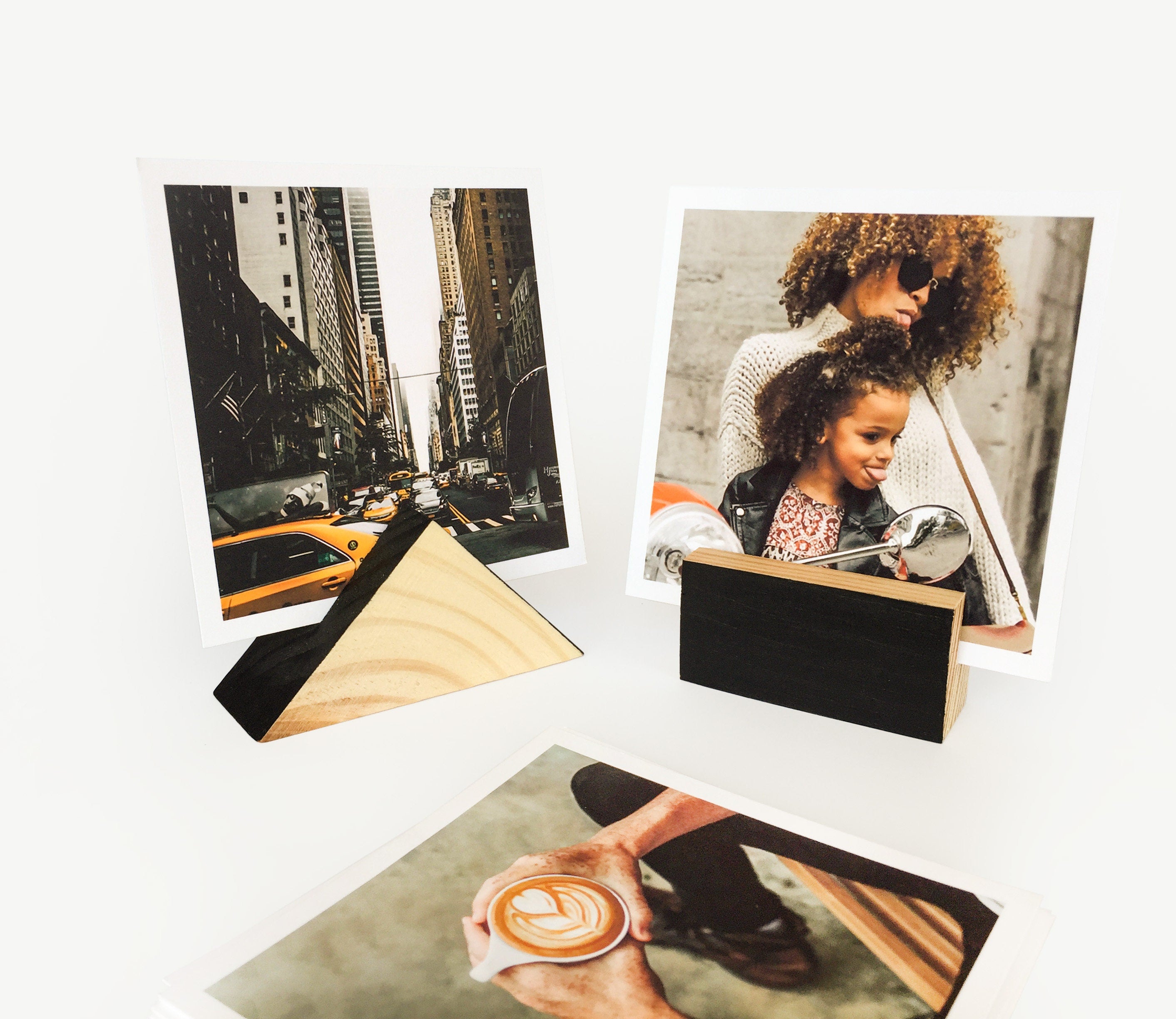 A stylish black wood block card holder displaying various art prints and photos, perfect for desks and shelves.