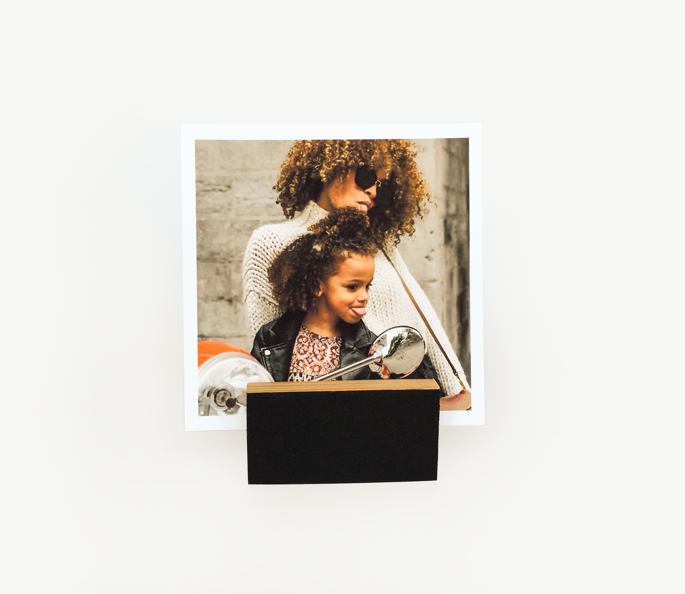 A stylish black wood block card holder displaying various art prints and photos, perfect for desks and shelves.