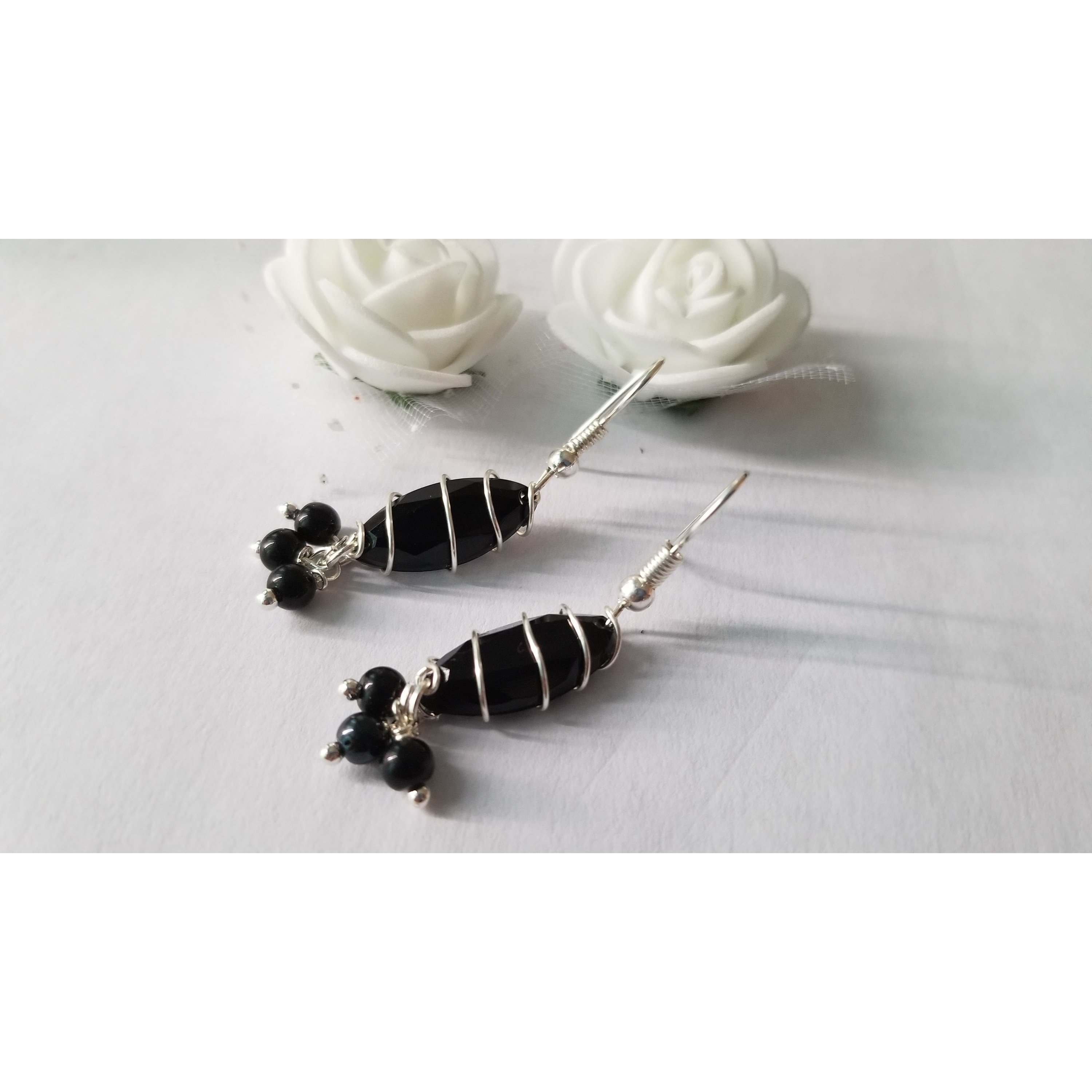 Elegant handmade black drop earrings with dangle design, showcasing unique craftsmanship.