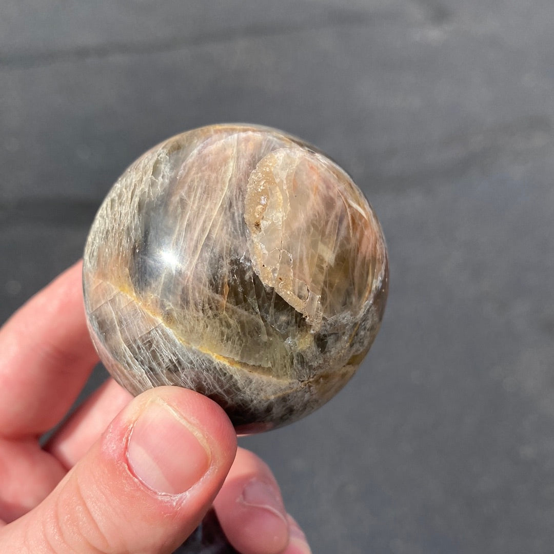 A beautiful Black Moonstone Sphere with a dark gray to black body and shimmering silvery sheen, perfect for meditation and emotional balance.