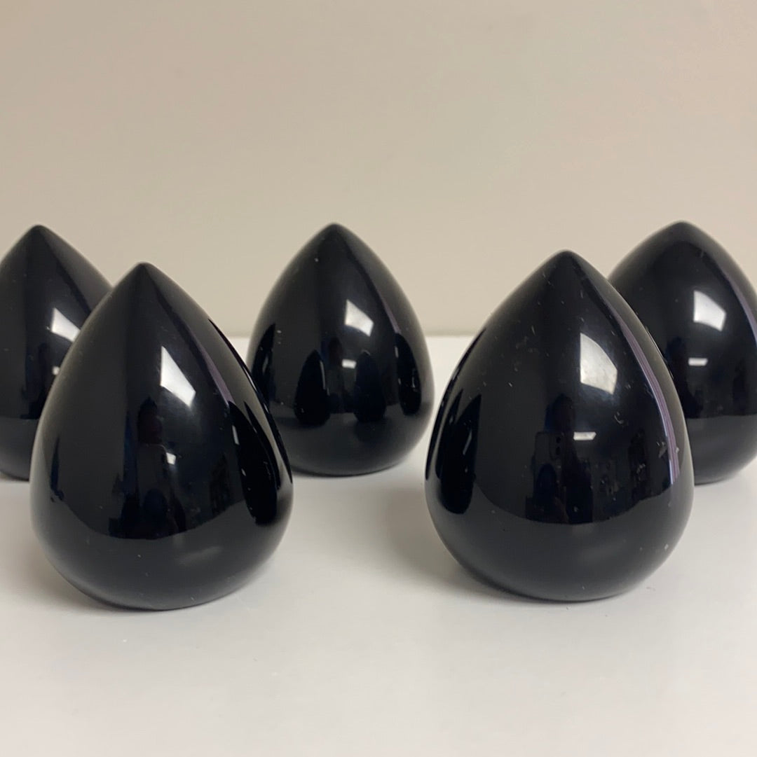 A polished Black Obsidian Cut Base Egg, showcasing its glossy surface and deep black color, standing 2.5 inches tall.