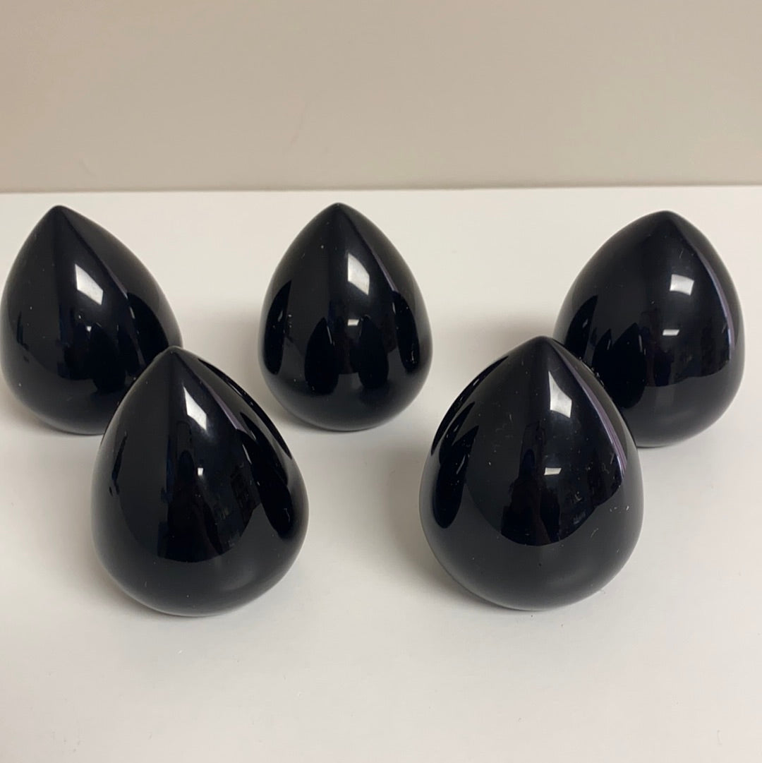 A polished Black Obsidian Cut Base Egg, showcasing its glossy surface and deep black color, standing 2.5 inches tall.