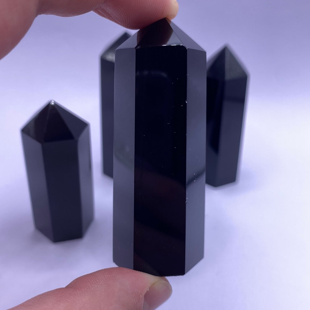 A beautiful Black Obsidian Faceted Point, showcasing its glossy surface and unique shape, perfect for healing and decoration.