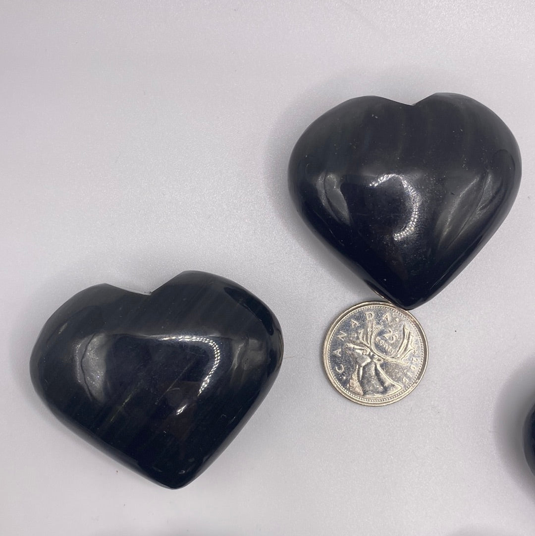 A polished Black Obsidian Heart, 2 inches wide, showcasing its glossy surface and natural volcanic glass texture.