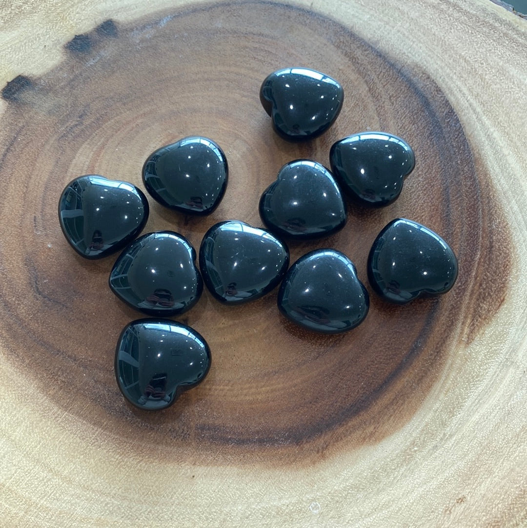 A polished Black Obsidian Heart crystal with a glossy finish, symbolizing protection and emotional healing.