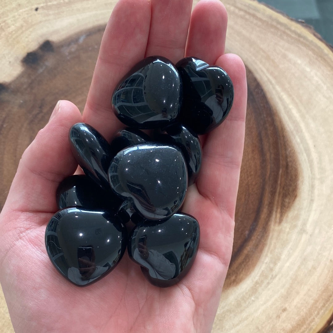 A polished Black Obsidian Heart crystal with a glossy finish, symbolizing protection and emotional healing.