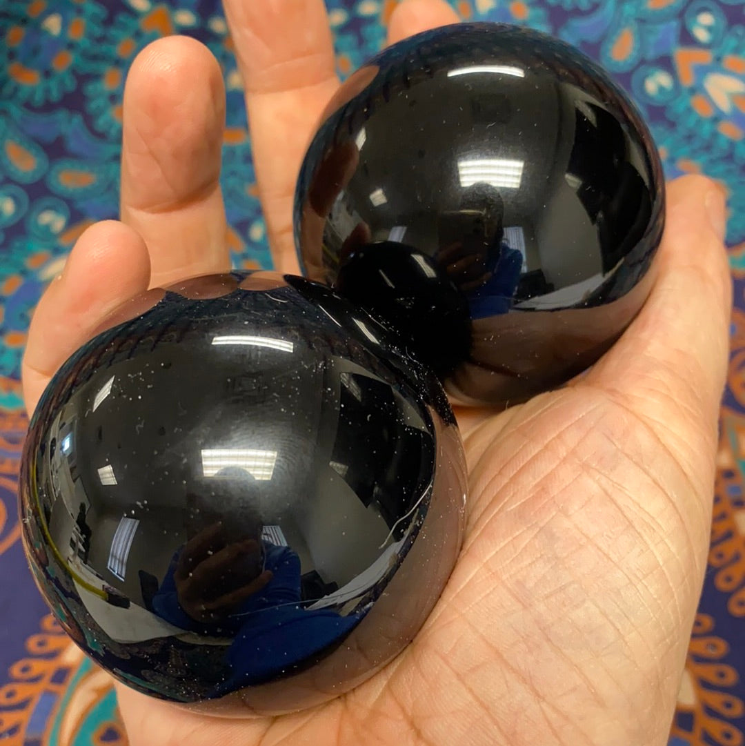 A polished Black Obsidian Sphere, approximately 2.5-3 inches in diameter, showcasing its unique glossy surface and deep black color.