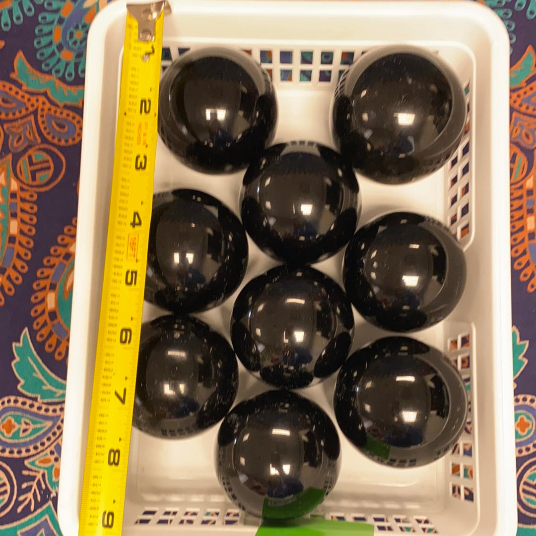 A polished Black Obsidian Sphere, approximately 2.5-3 inches in diameter, showcasing its unique glossy surface and deep black color.