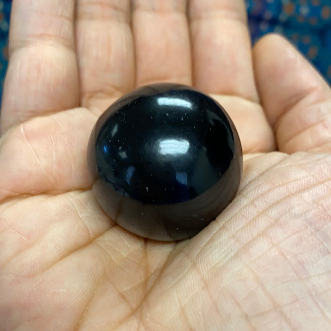 A polished Black Obsidian Sphere showcasing its smooth, glossy surface and deep black color, perfect for energy healing and decoration.