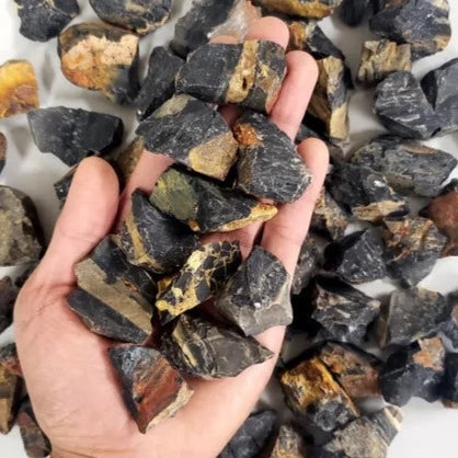 A collection of raw black onyx chunks showcasing their natural texture and deep black color, ideal for emotional healing and grounding.