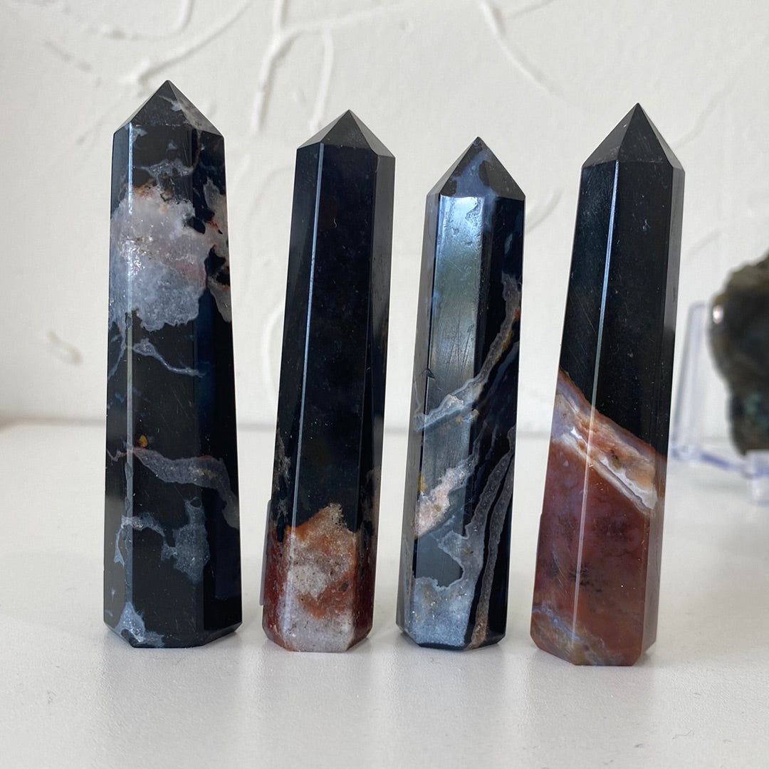 A collection of Black Sardonyx Faceted Points, showcasing their unique shapes and rich black color with subtle bands.