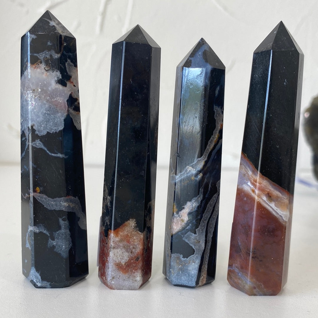 A collection of Black Sardonyx Faceted Points, showcasing their unique shapes and rich black color with subtle bands.