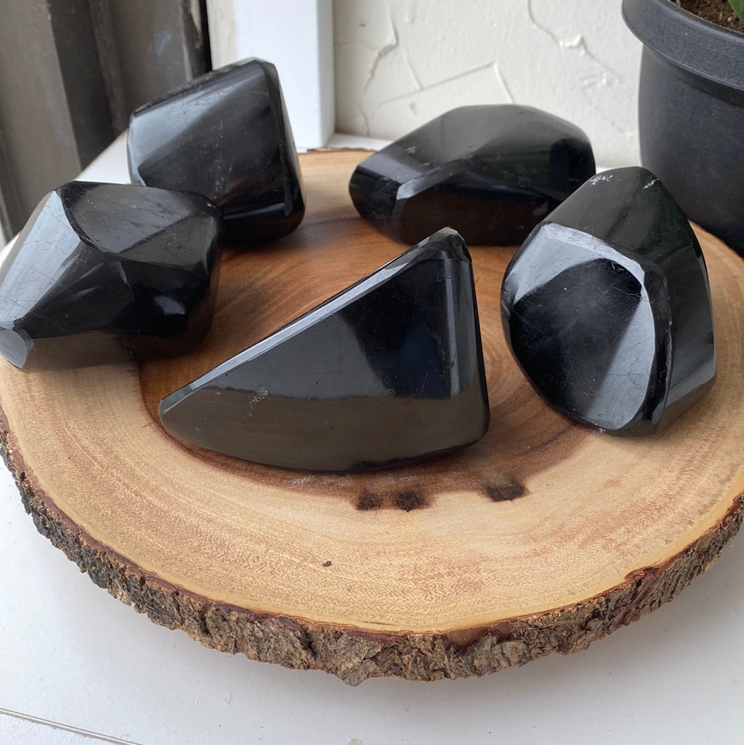 A large, striking Black Tourmaline Freeform crystal showcasing its deep black color and unique shape, perfect for energy protection.