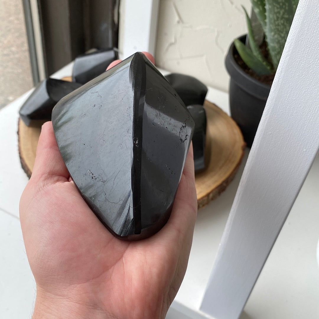 A large, striking Black Tourmaline Freeform crystal showcasing its deep black color and unique shape, perfect for energy protection.