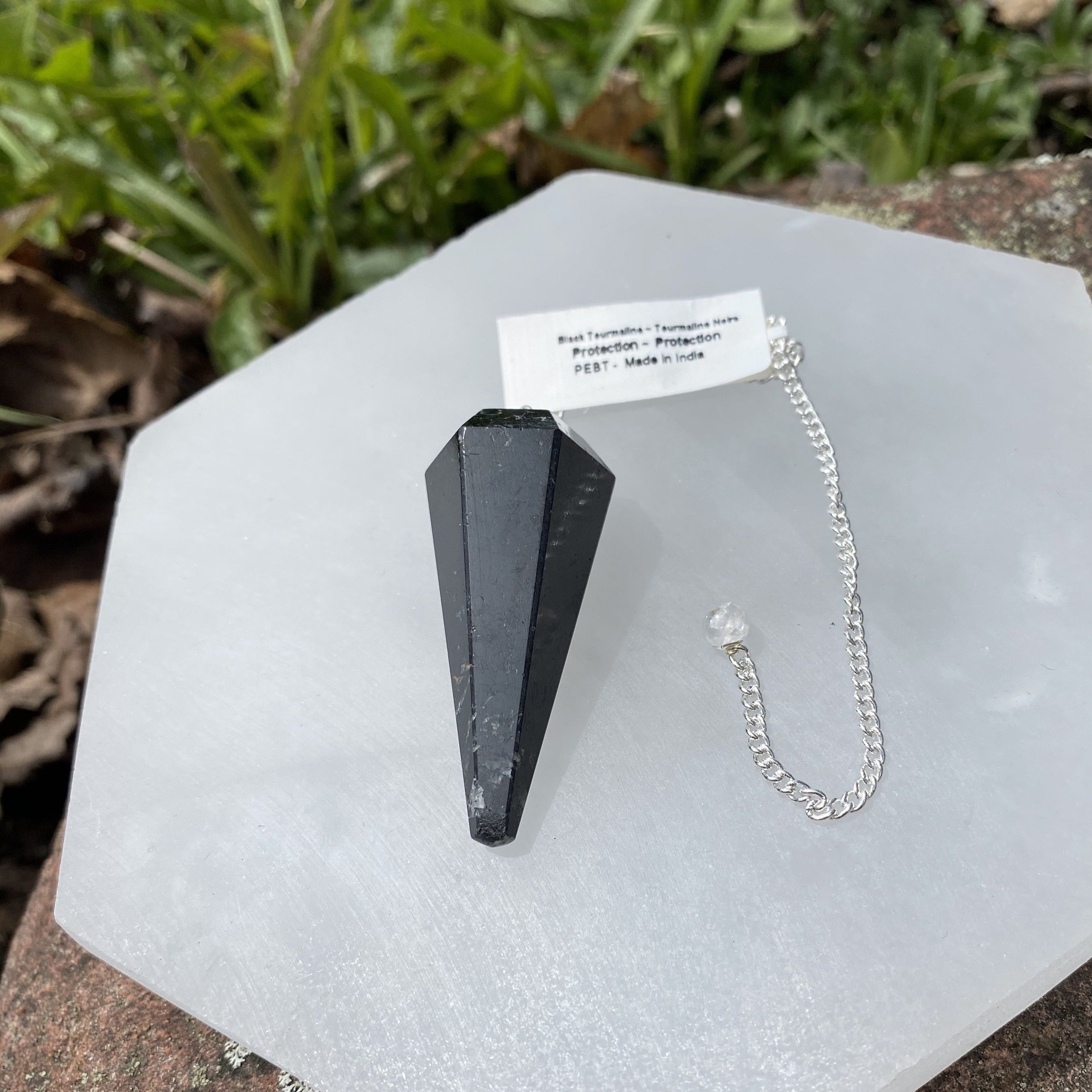 Black Tourmaline Pendulum on a silver chain, showcasing its unique gemstone properties.