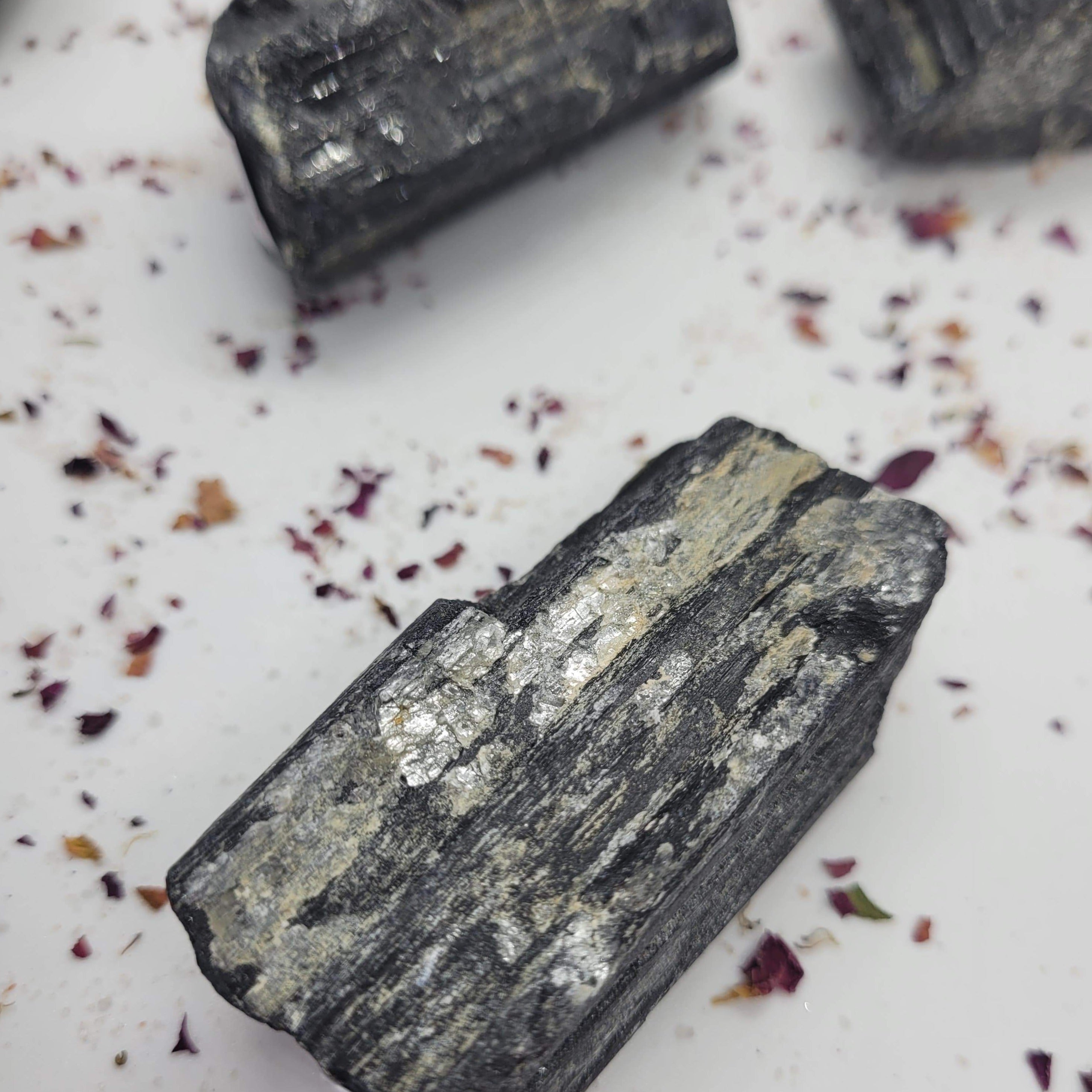 Raw chunks of Black Tourmaline showcasing their unique textures and deep black color, ideal for protection and grounding.