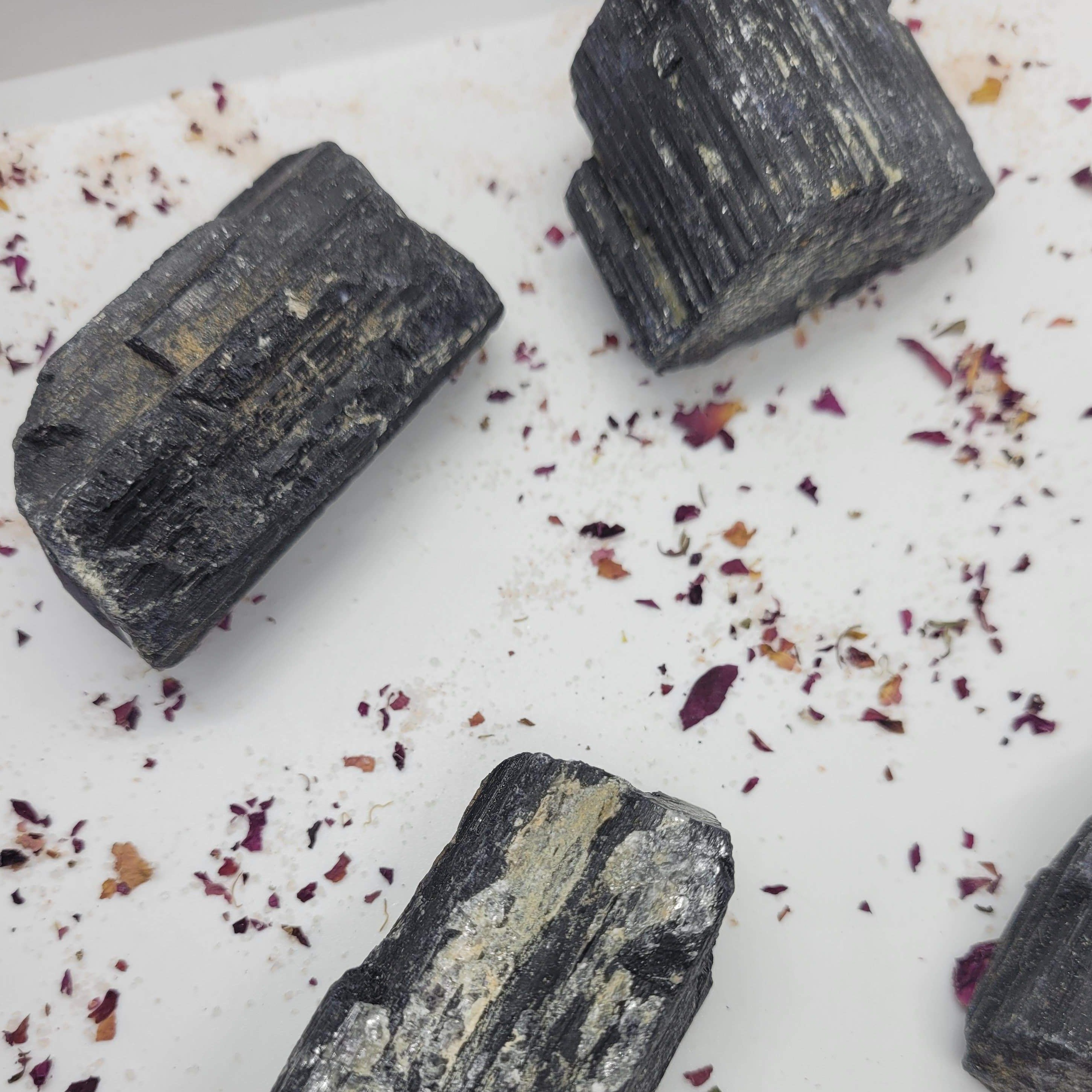 Raw chunks of Black Tourmaline showcasing their unique textures and deep black color, ideal for protection and grounding.