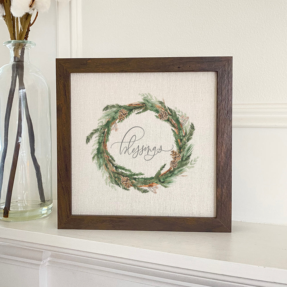 A beautifully framed Blessings Wreath sign with a natural linen-look background and eco-friendly ink printing, perfect for home decor.