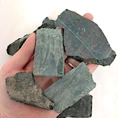 A collection of rough bloodstone slabs showcasing their unique textures and rich colors, ideal for healing and crafting.