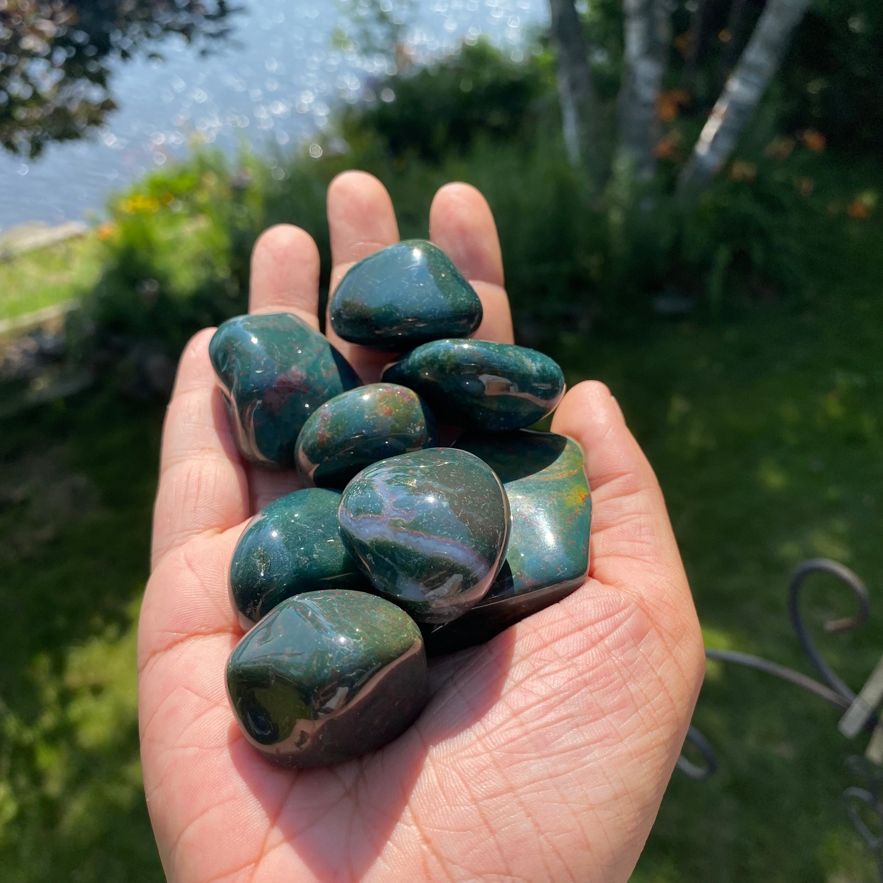 A collection of Bloodstone Tumbled Stones showcasing their unique green and red patterns, perfect for healing and meditation.