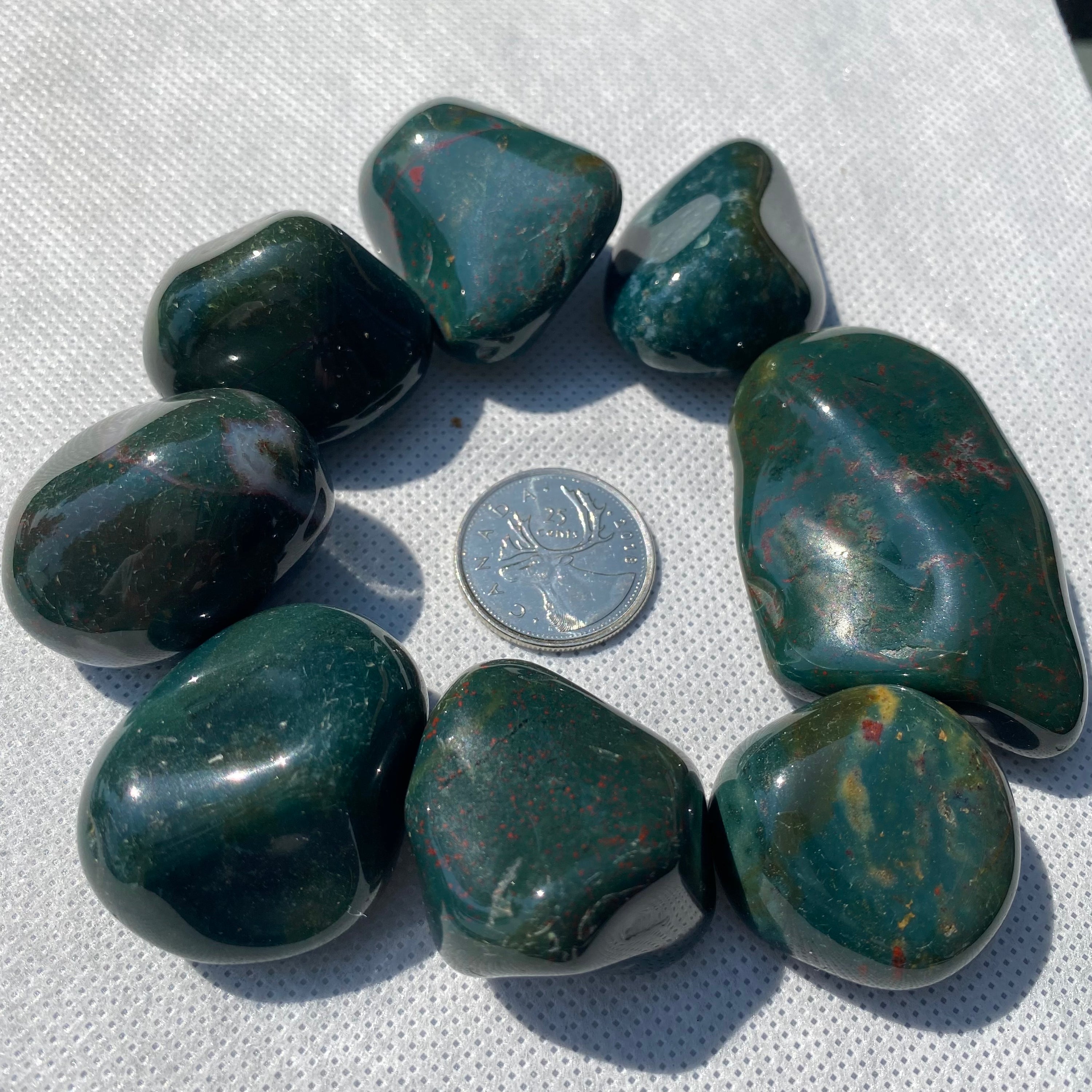 A collection of Bloodstone Tumbled Stones showcasing their unique green and red patterns, perfect for healing and meditation.