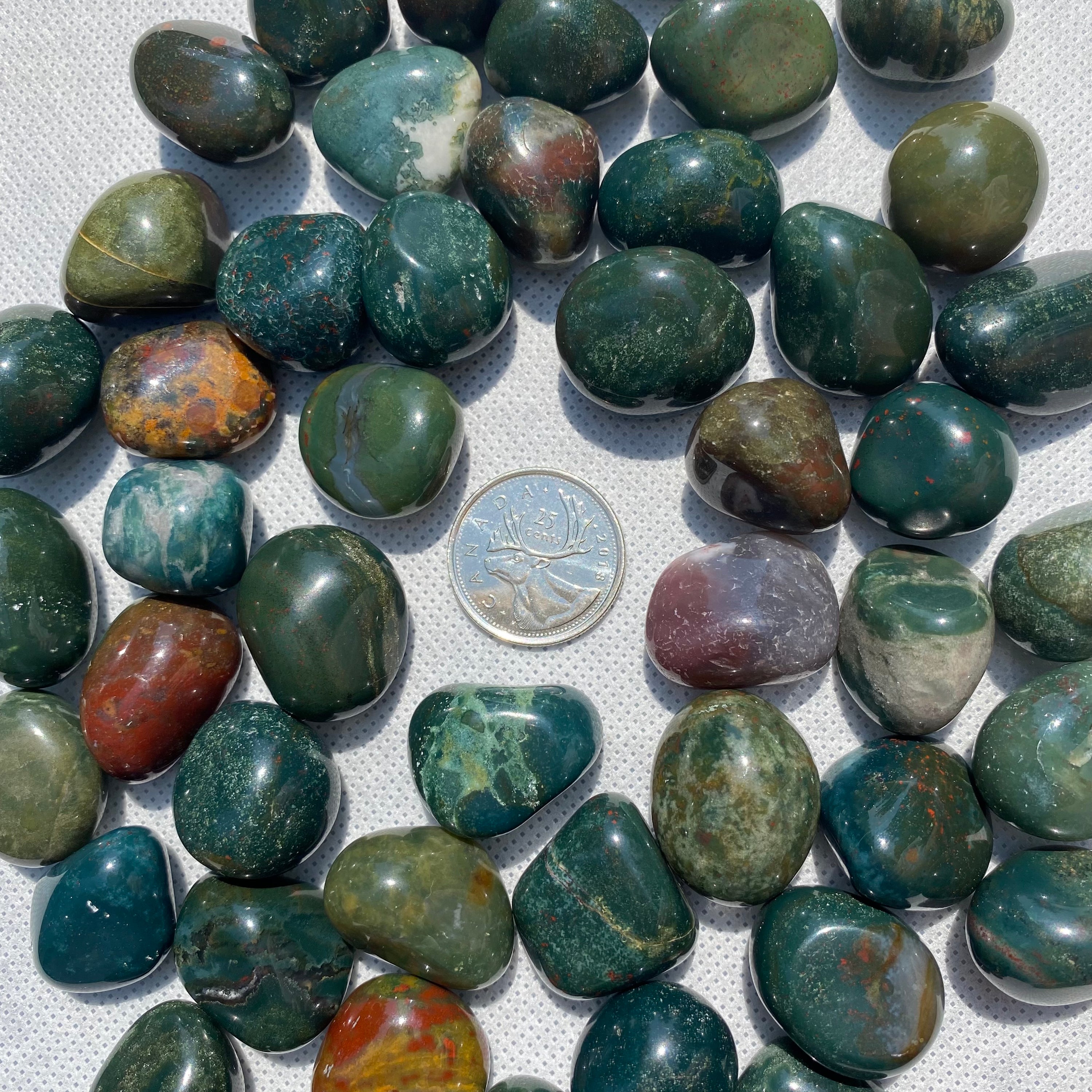 A collection of Bloodstone Tumbled Stones showcasing their unique green and red colors, perfect for healing and grounding.