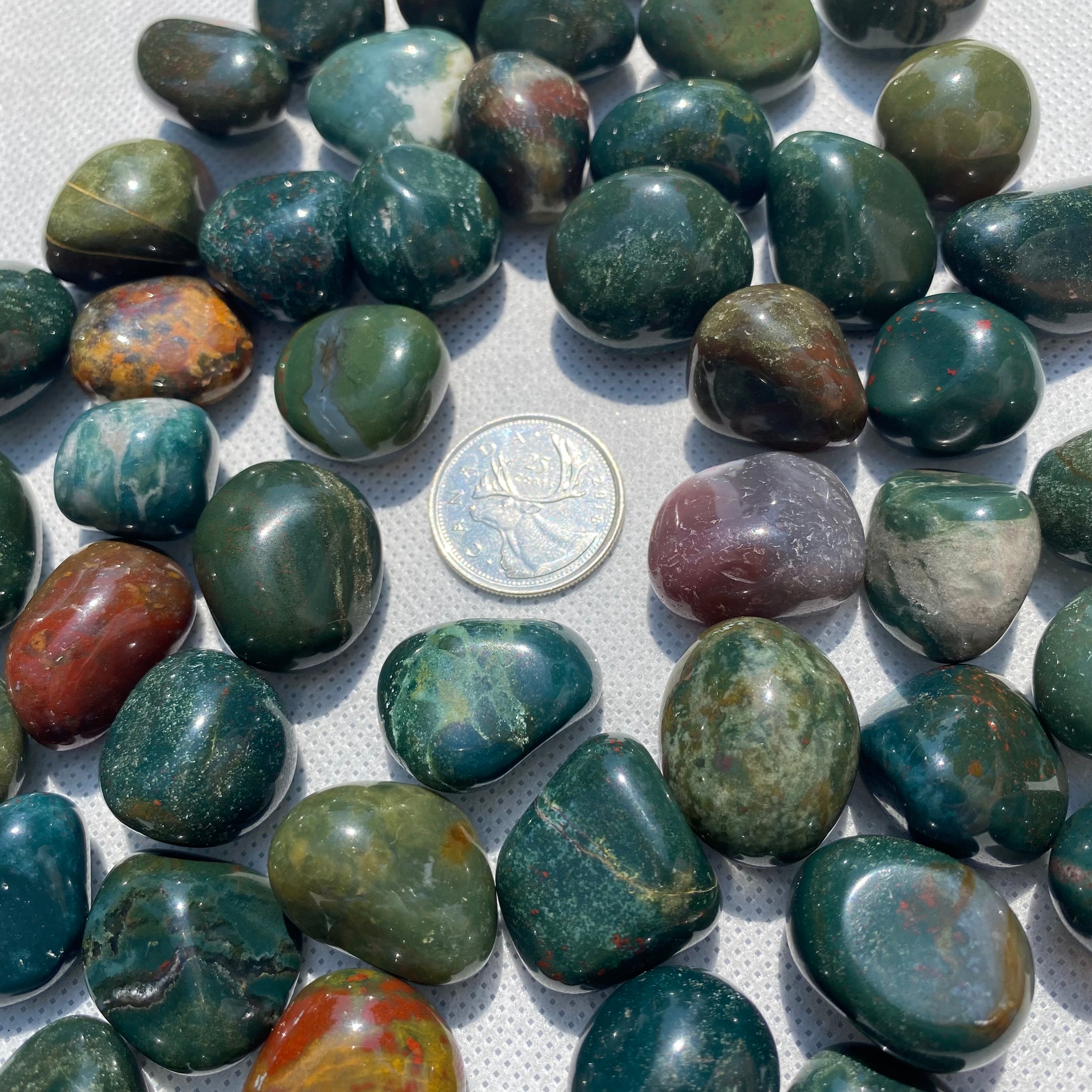 A collection of Bloodstone Tumbled Stones showcasing their unique green and red colors, perfect for healing and grounding.