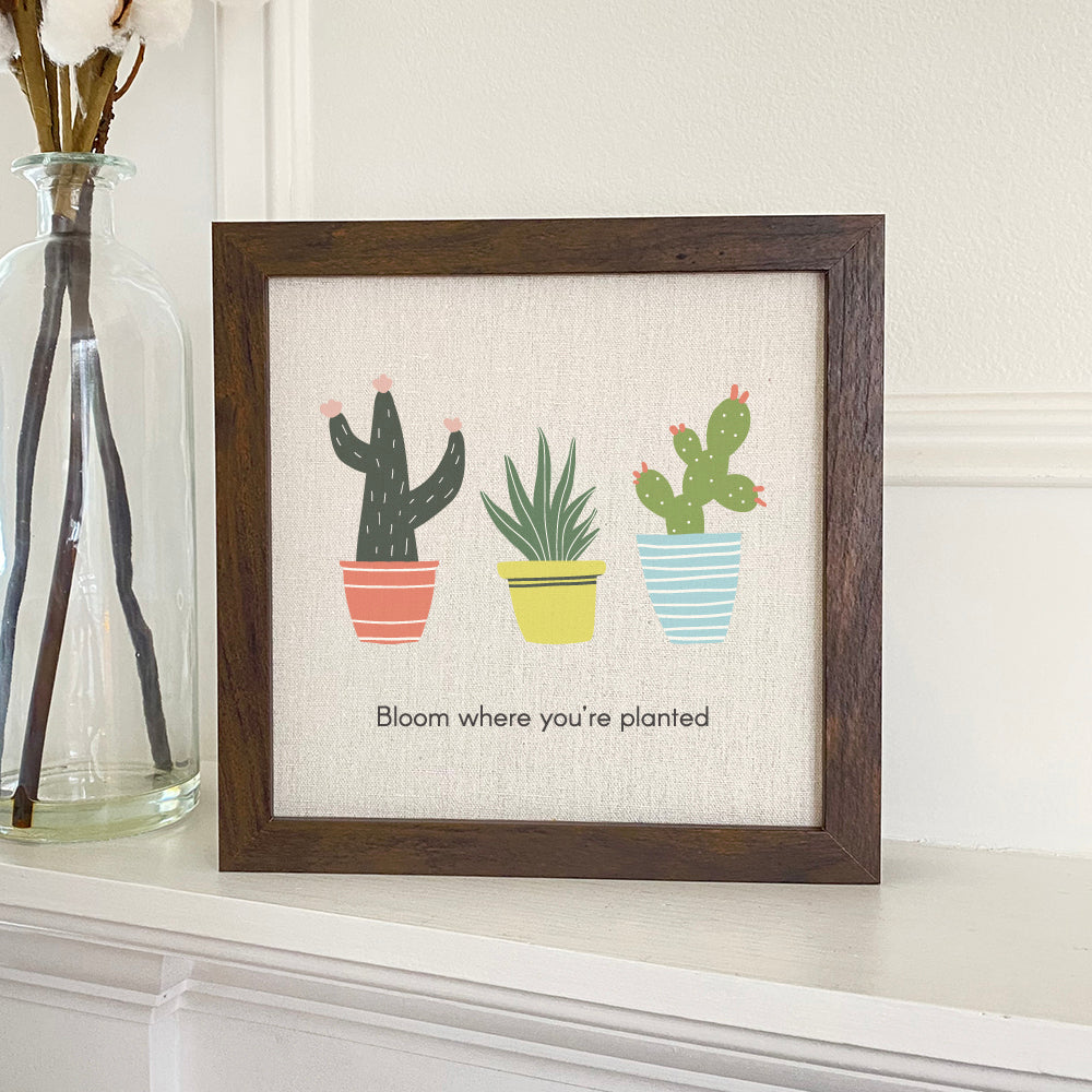 Bloom Where You're Planted framed sign with a wood frame and linen-look background, featuring a cactus design.