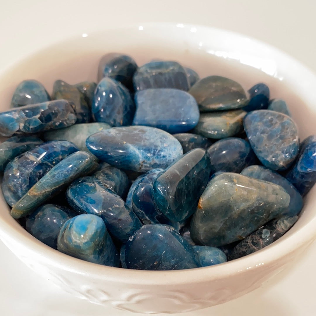 A polished Blue Apatite Tumbled Stone showcasing its deep aqua color and smooth surface, perfect for healing and meditation.