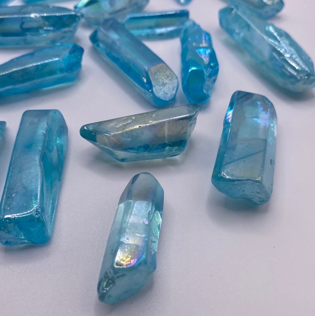 A beautiful Blue Aura Quartz Point with an iridescent blue color and prismatic shape, radiating healing energy.