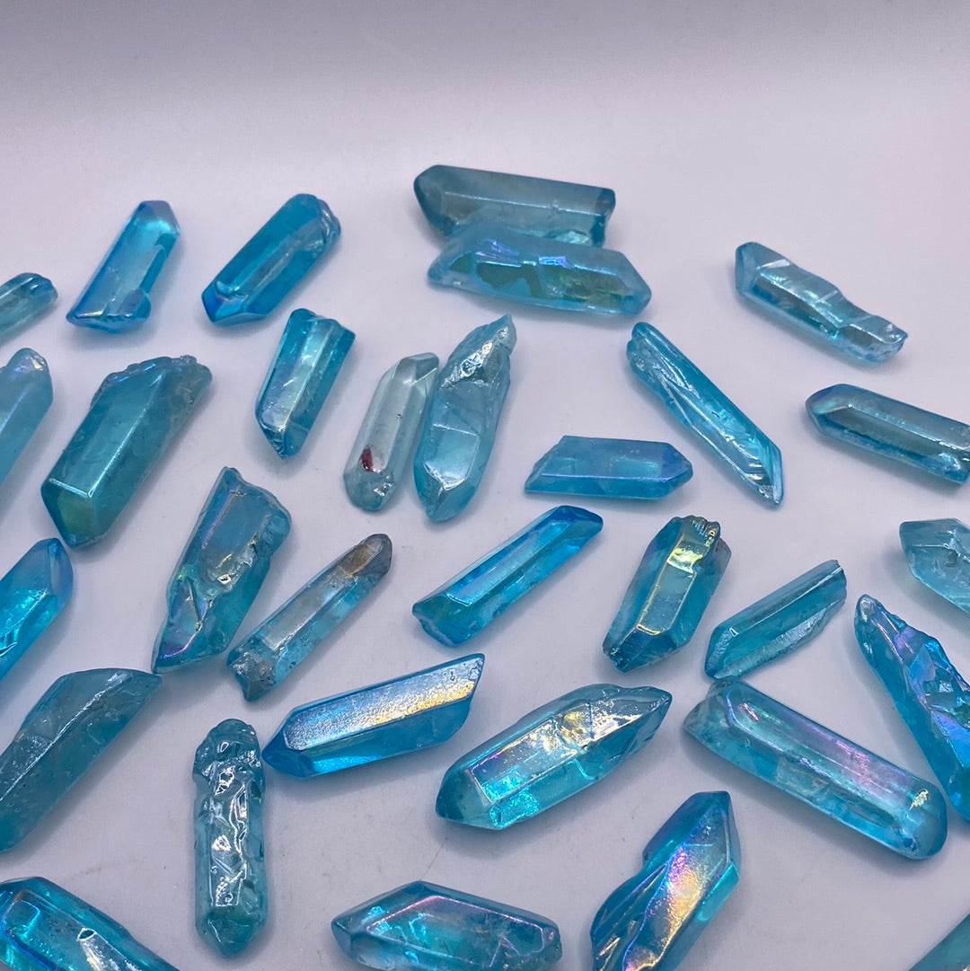 A beautiful Blue Aura Quartz Point with an iridescent blue color and prismatic shape, radiating healing energy.