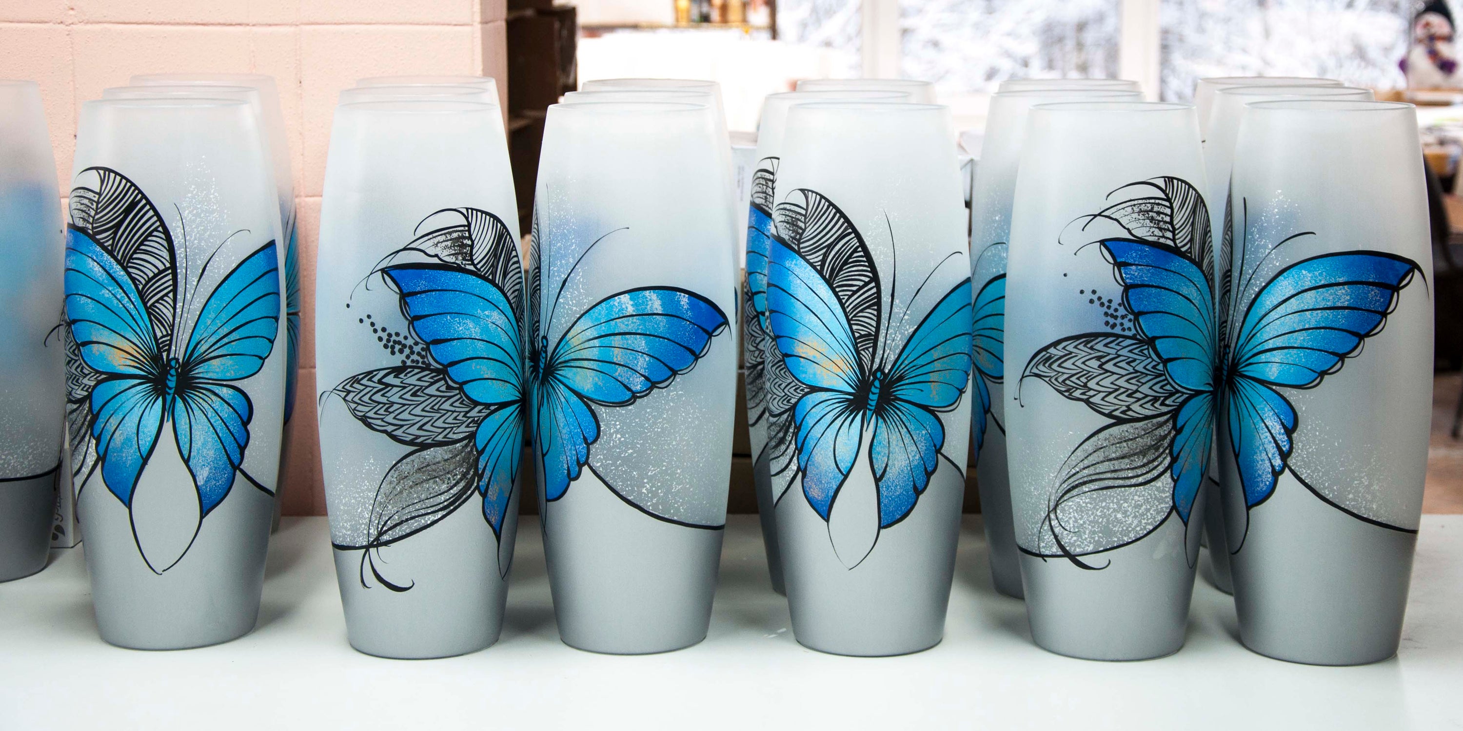 Large handpainted glass vase featuring a blue butterfly design, perfect for displaying flowers.