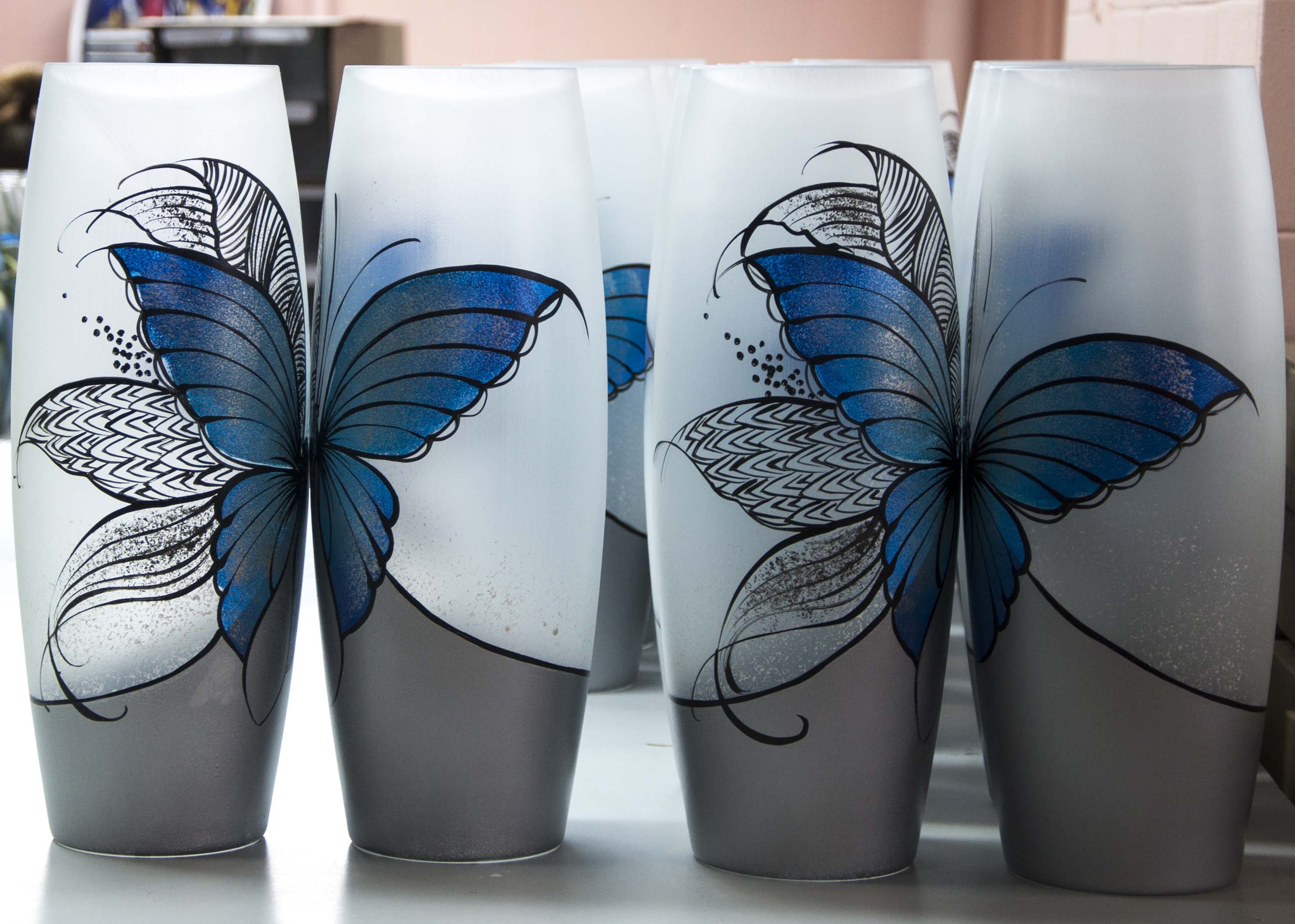 Large handpainted glass vase featuring a blue butterfly design, perfect for displaying flowers.