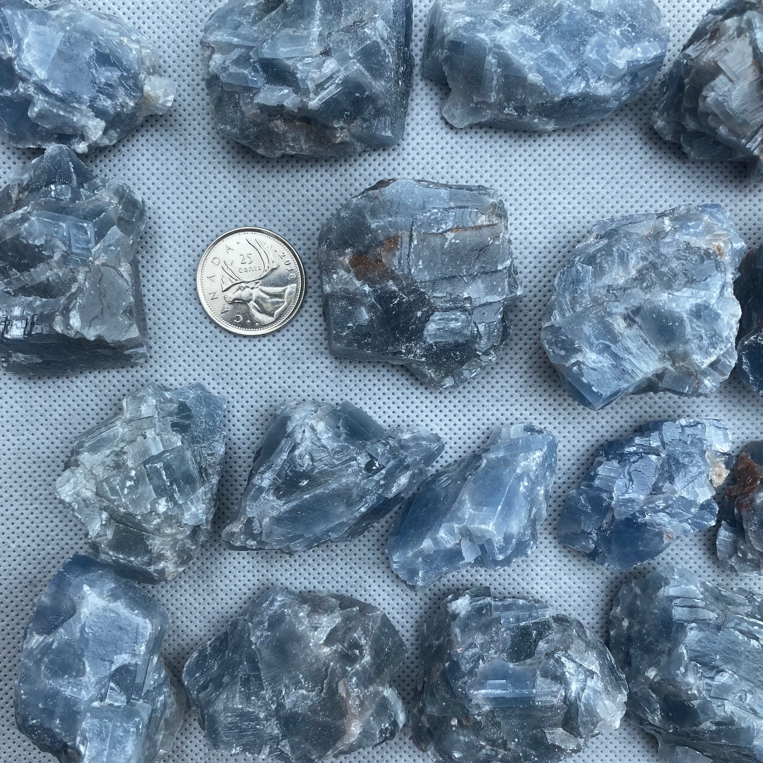 Natural rough cut blue calcite pieces showcasing various shapes and sizes, radiating calming energy.