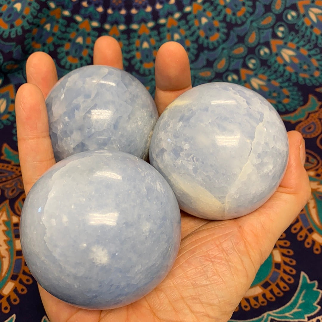 A collection of blue calcite spheres showcasing various shapes and sizes, radiating calming energy.