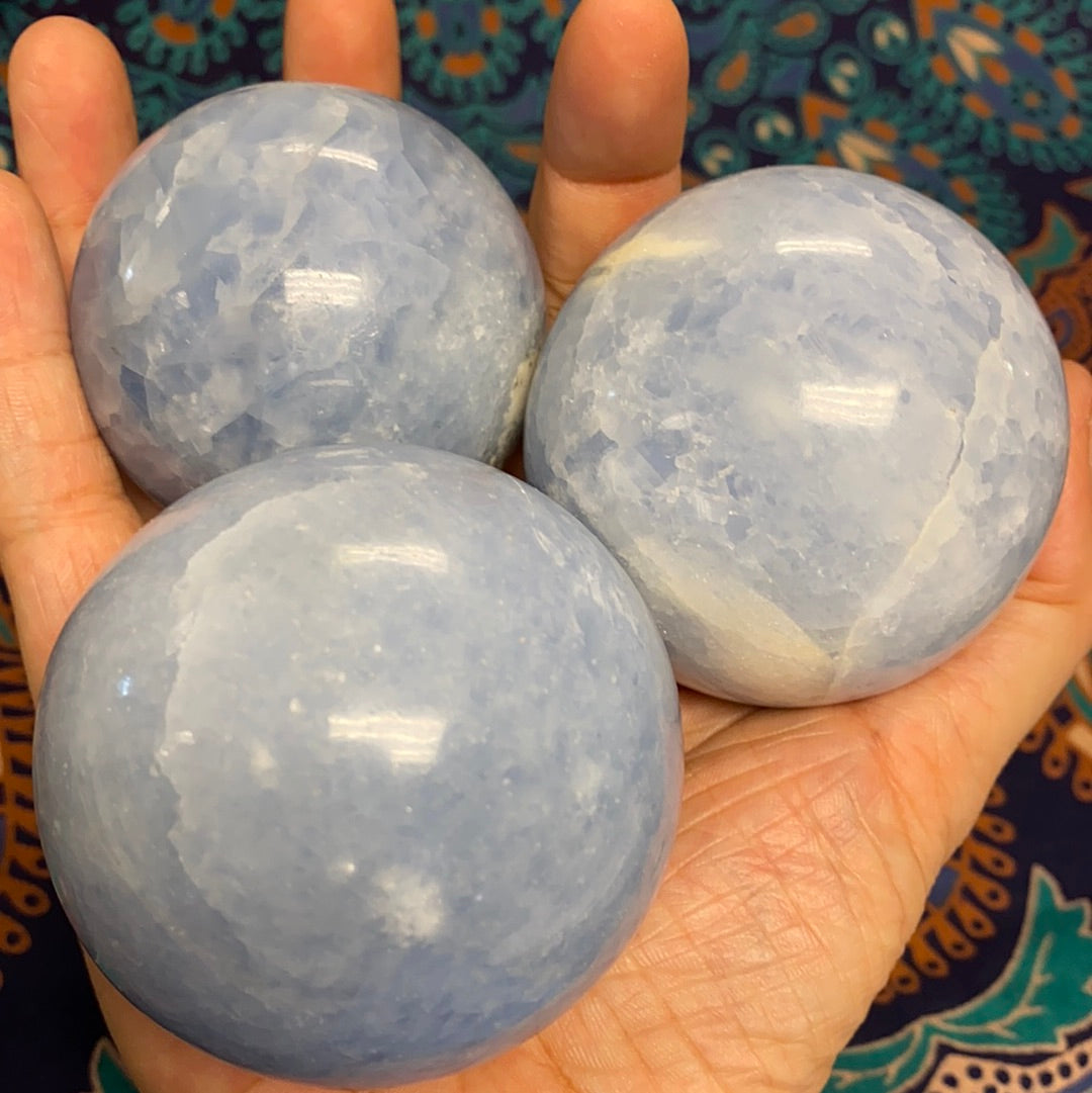 A collection of blue calcite spheres showcasing various shapes and sizes, radiating calming energy.